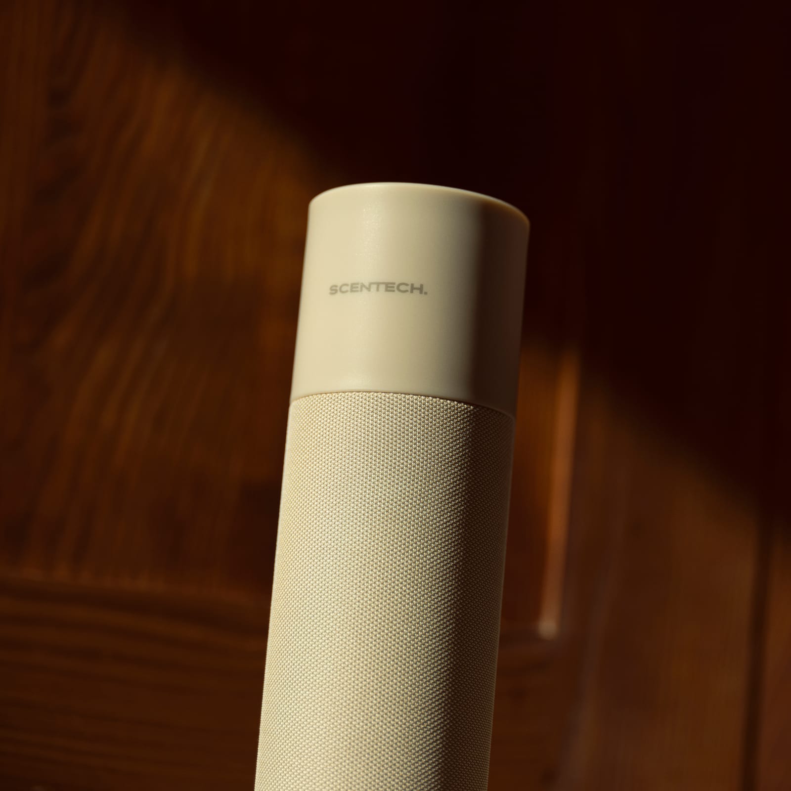 Close-up of the Scentech Smart Aroma Diffuser 2 in low sun against a walnut wall