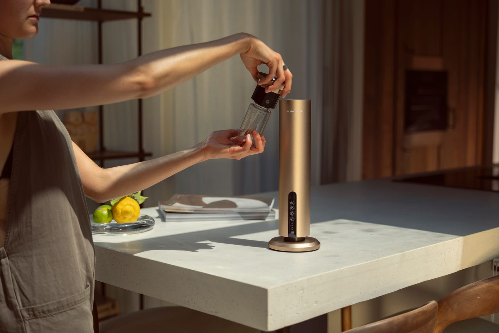 A woman lifts the ScentPod out of the top of the Smart Aroma Diffuser Pro to change it